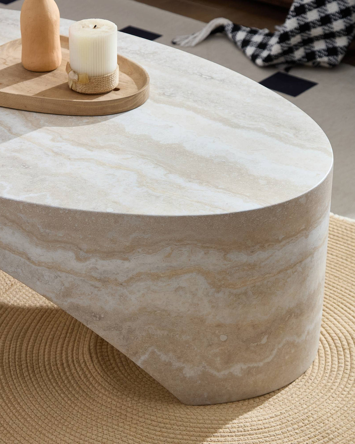 Beige marble coffee table with decorative items on a rug