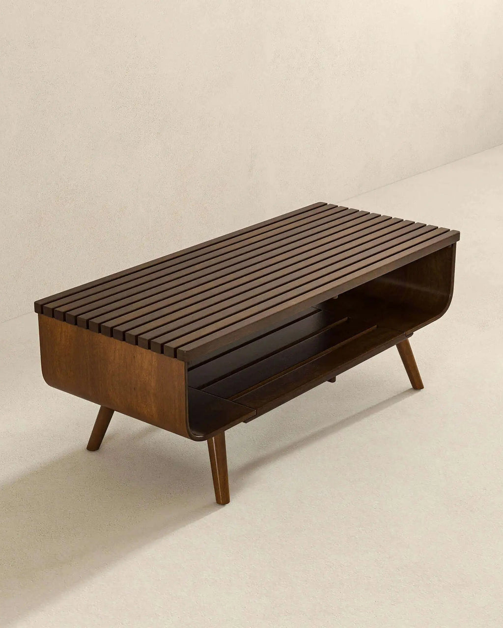 Mid-century modern wooden storage bench with a slatted top, open lower shelf, and tapered legs, shown in a minimalist beige room setting.