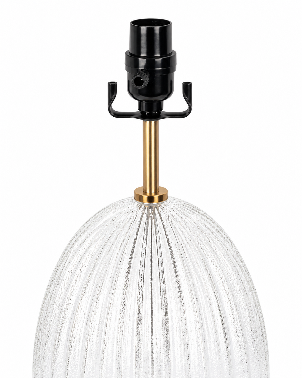 A close-up of a table lamp featuring a textured clear glass shade with vertical ribbing, a polished brass stem, and a black socket with a hanger tab, set against a plain white background.